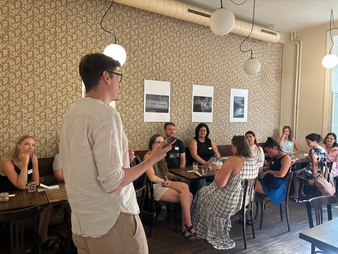 An organiser speaking to the group at Café Podnebí in Brno
